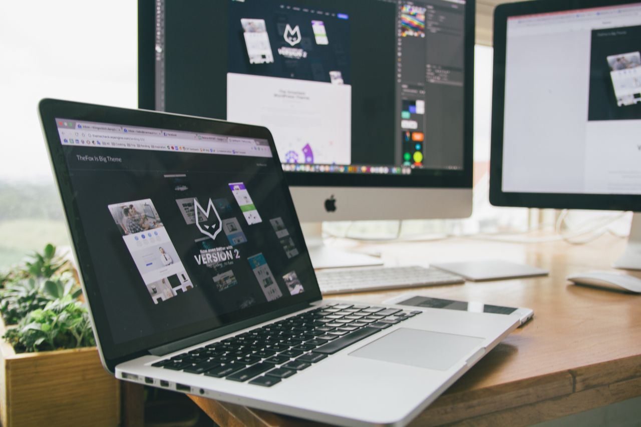 Un espace de travail élégant avec un ordinateur portable et des écrans affichant un logiciel de conception.